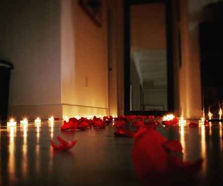 Tanner Buchanan placing rose petals with candles on the side for Lizze Broadway.